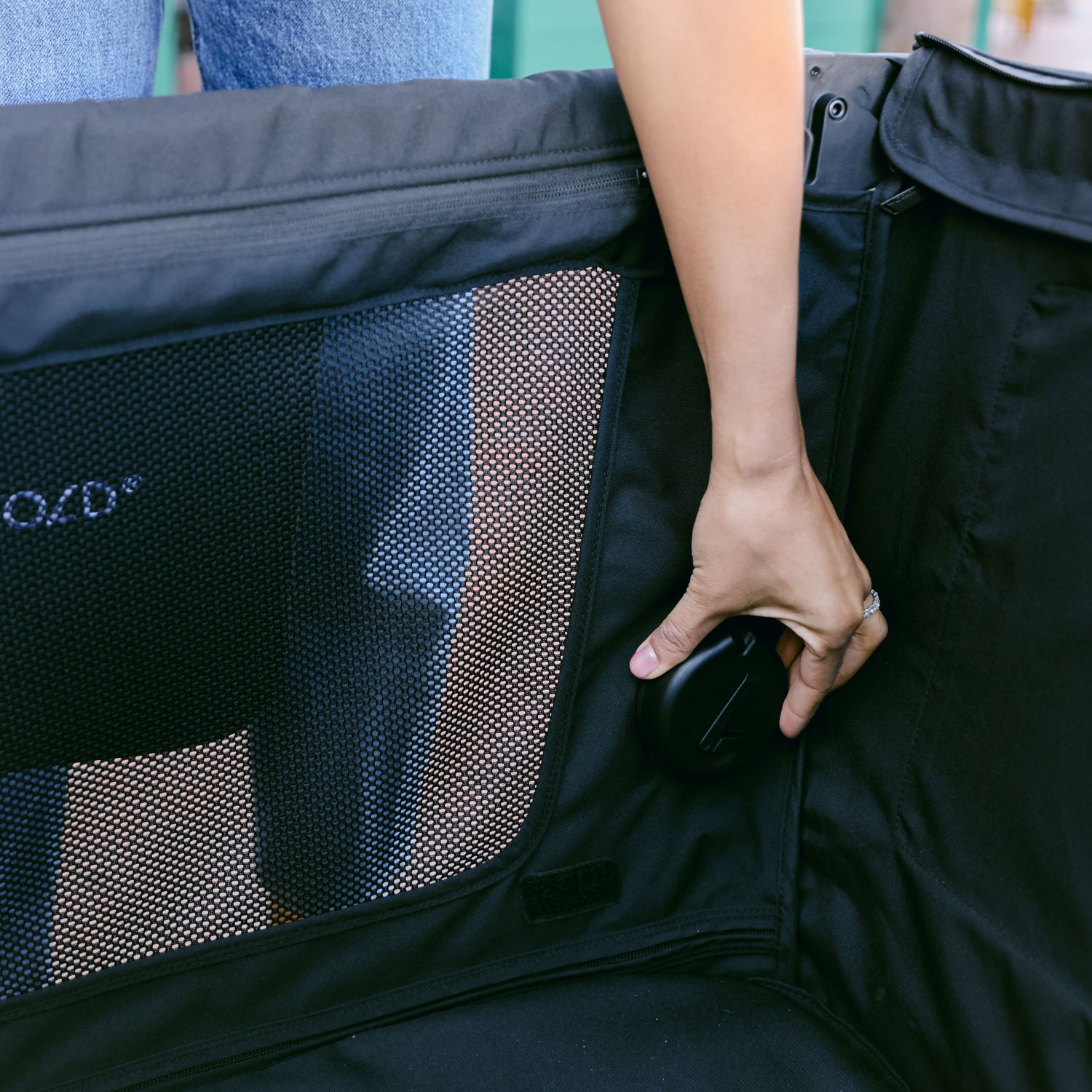 Close-up of a person adjusting the seat mount cover inside the WonderFold L4 stroller wagon, for when the seat is not in use.