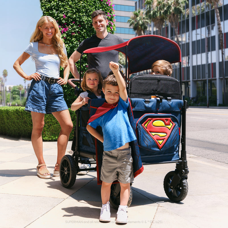 Family with a Superman-themed stroller on a city street.