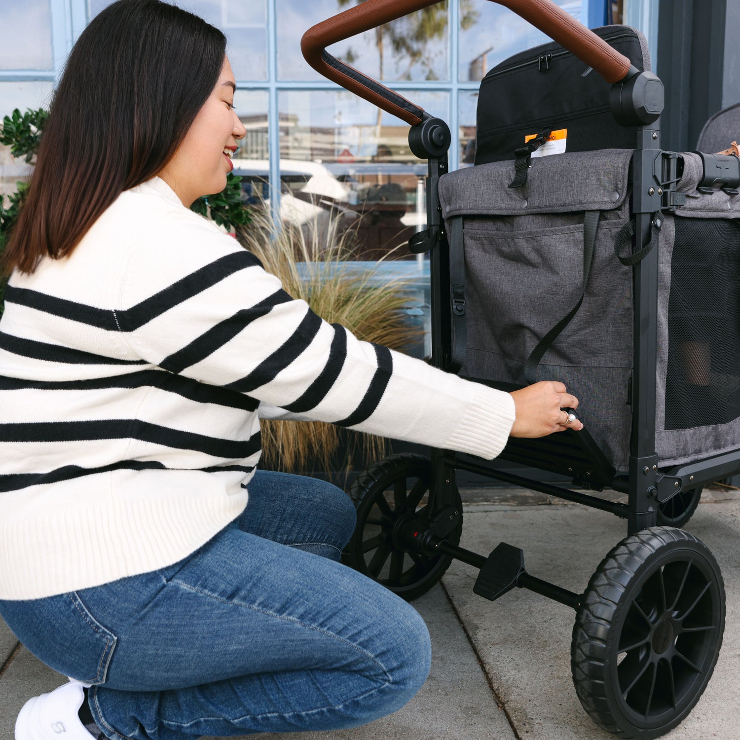 Close-up of a mother attaching the Buddy Board to a WonderFold stroller wagon