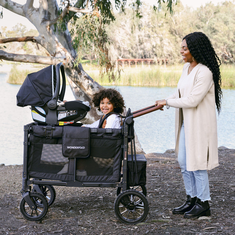mom pushing toddler stroller wagon with infant seat adapter 